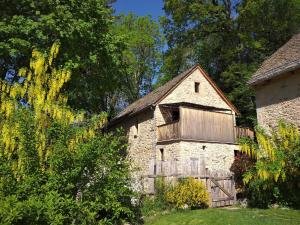 an old stone building with a gate and a barn at Domaine des Marequiers chambre Silène in Saint-Germain-du-Teil