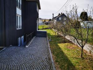 een huis met een stenen loopbrug naast een gebouw bij Apart Hotel in Gjøvik