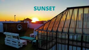 a sunset over a building with the words sunset at Lion Hostel By Rebels kiteschool in Tarifa