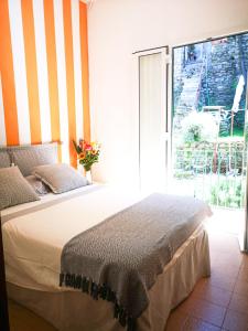 ein Schlafzimmer mit einem Bett und einem großen Fenster in der Unterkunft Punto Zero in Corniglia