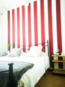 a bedroom with a red and white striped wall at Punto Zero in Corniglia