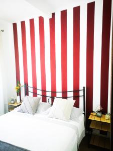 a bedroom with two beds and a red and white striped wall at Punto Zero in Corniglia