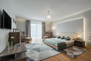 a bedroom with a bed and a living room at Hotel Smile Pieniny in Szczawnica