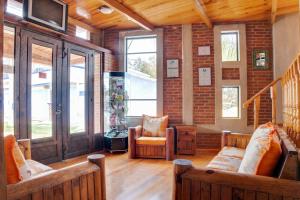 a living room with wooden floors and a brick wall at Hotel Bello Amanecer in Mineral del Chico