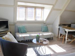 a living room with a couch and a table at Casa duna close to the beach, city centre, dunes and parking area in Zandvoort
