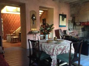Le Carroy Brion في Cinais: طاولة غرفة الطعام مع إناء من الزهور عليها