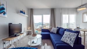 Bed&Bcn Glories في برشلونة: غرفة معيشة مع أريكة زرقاء وتلفزيون