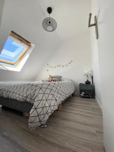 1 dormitorio con cama y ventana en Escapade à Cabourg, 300M plage, calme et chaleureux, en Cabourg