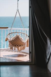 a hammock hanging on a balcony overlooking the ocean at Yellow's Kenting B&B II in Eluan