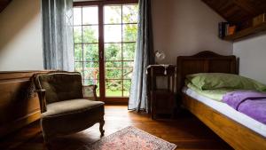 sypialnia z łóżkiem, krzesłem i oknem w obiekcie Villa Kuligi w mieście Kuligi