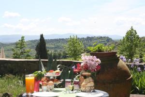 einen Tisch mit Essen und Blumen auf dem Tisch mit Aussicht in der Unterkunft Fattoria San Donato in San Gimignano