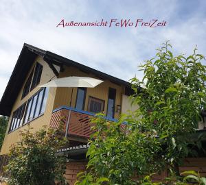 a house with a balcony with an umbrella at FeWoFreiZeit in Rheinau