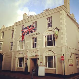 a large building with a flag on top of it at Fountain Inn by Greene King Inns in Cowes