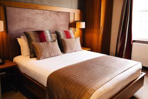 a bedroom with a large bed with pillows at Busby Hotel in Busby