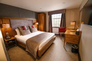 a hotel room with a large bed and a desk at Busby Hotel in Busby