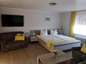 um quarto de hotel com uma cama grande e um sofá em Pension Arndt UG em Wangerland