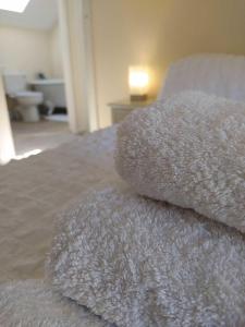 a pile of pillows sitting on top of a bed at French Horn Cottage in Ware