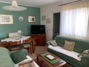 サン・ジョルジョにあるMini Villetta San Giorgioのリビングルーム(緑のソファ、テーブル付)
