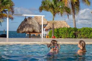 two children in the swimming pool at a resort at Almond Beach Resort at Jaguar Reef in Hopkins