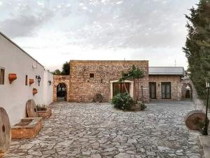 a large stone courtyard with a brick building at Masseria Artemisia in Torre San Giovanni Ugento