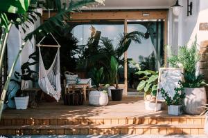 a porch with potted plants and a hammock at Yellow's Kenting B&B II in Eluan