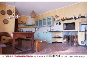 kuchnia z niebieskimi szafkami i drewnianym stołem w obiekcie Appartamento A in villa con vista panoramica w mieście San Salvatore