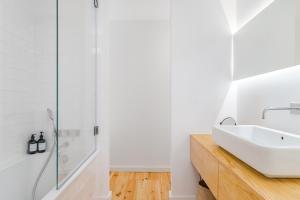 een witte badkamer met een wastafel en een douche bij Casa Boma Lisboa - Charming and Typical Apartment - Lapa III in Lissabon