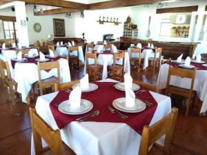a dining room with tables with red and white table settings at Casa Hacienda Nasca Oasis in Nazca