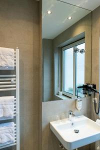 a bathroom with a sink and a mirror at Hotel Fischertor in Augsburg