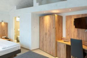奧格斯堡的住宿－費舍爾特爾酒店，一间卧室配有一张床和一个木制橱柜