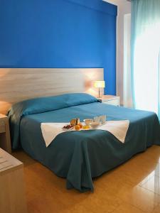 - un lit bleu avec une table et de la nourriture dans l'établissement Hotel Conchiglia d'Oro, à Mondello