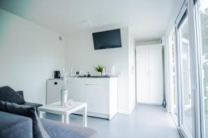 a white living room with a couch and a table at Maximus domki in Krynica Morska