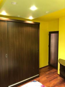 a room with a large wooden door and yellow walls at Clau Apartment in Galaţi
