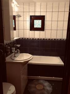 a bathroom with a sink and a tub and a toilet at Clau Apartment in Galaţi