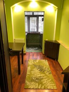 a room with green walls and a table and a rug at Clau Apartment in Galaţi