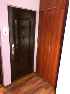 una gran puerta de madera en una habitación con suelo de madera en Clau Apartment, en Galaţi
