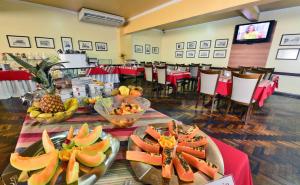 a dining room with a table with fruit on it at Curi Palace Hotel in Pelotas