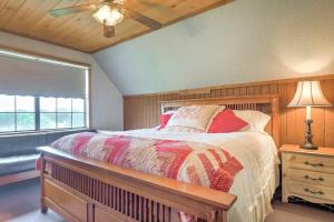 Un dormitorio con una cama y un ventilador de techo. en On Farm Rustic Carmine Log Cabin with Porch!, en Carmine