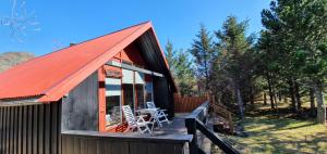 eine Hütte mit einem orangenen Dach und einem Deck in der Unterkunft Bard Cottage in Akranes