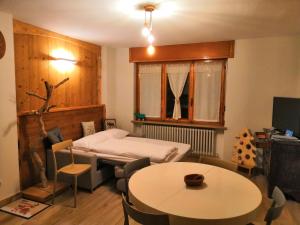 サン・ピエールにあるA Casa di Agnese - Alloggio ad uso turistico - VDA - SAINT-PIERRE - n 0001 e 0011のベッド、テーブル、椅子が備わる客室です。