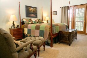 a bedroom with a bed and a chair and a couch at Berry Springs Lodge in Sevierville