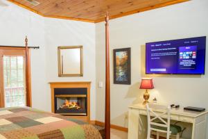 1 dormitorio con cama, escritorio y chimenea en Berry Springs Lodge en Sevierville