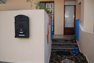una cassetta della posta su un muro bianco accanto a una porta di Apartment Conchiglie 2 a Cala Gonone