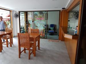 a dining room with a table and chairs in front of a store at Welcome Inn Hotel karon Beach Double room from only 600 Baht in Karon Beach