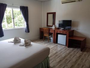 a room with a bed and a desk and a television at Welcome Inn Hotel karon Beach Double room from only 600 Baht in Karon Beach