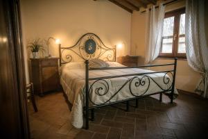 una camera con letto e struttura in ferro battuto di CASE&COLLINE Gelsomino a Montescudaio