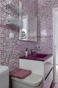 bagno con lavandino e parete piastrellata rosa di CASA DA FALÉSIA 28 - Casa a Peniche