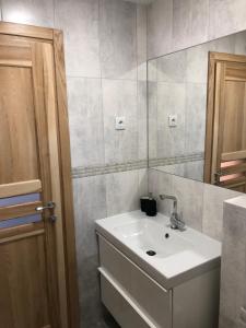 y baño con lavabo y espejo. en Villa Ievyne 2, en Paežeriai