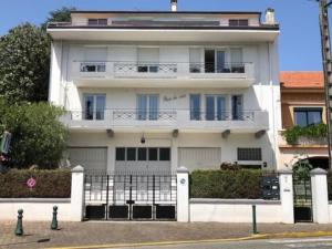 une maison blanche avec une clôture devant elle dans l'établissement Grand appartement de standing "Rêve du Soir" de 170 m2 350 m de la gare, à Lourdes