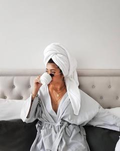 a woman in a robe drinking a cup of coffee at Hotel Once Bangkok in Bangkok